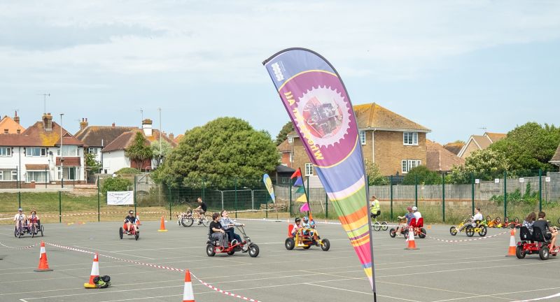 People riding around a playground on accessible bikes
