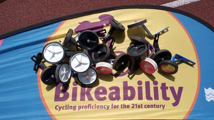 Bikeability flag with a pile of bike stabilisers